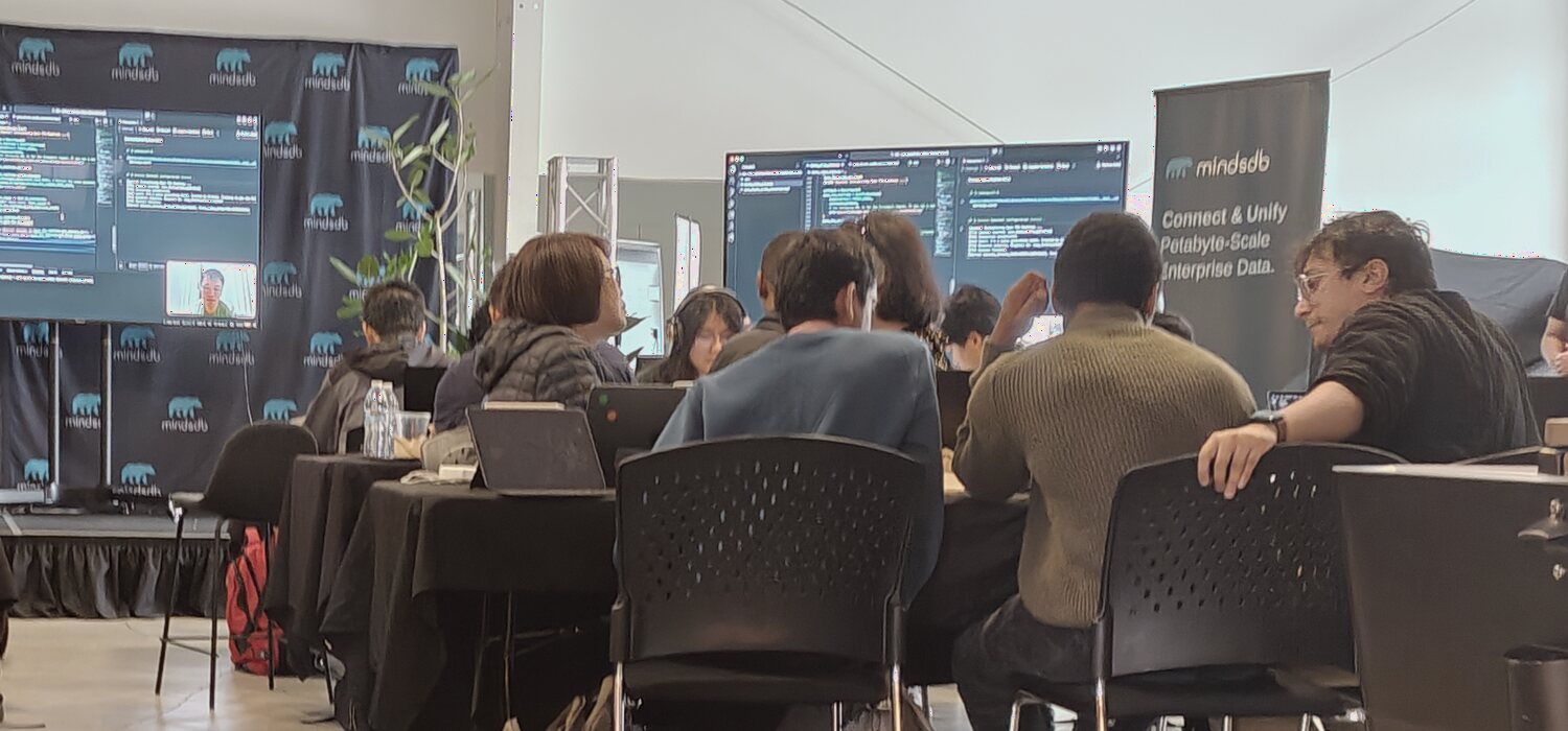 A Mindsmith workshop room with builders looking at code on large screens
